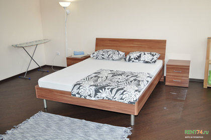 Большая двуспальная кровать, прикроватные тумбочки, стеллаж